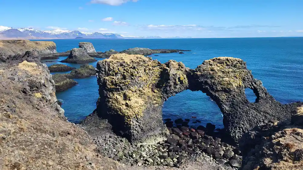Basalt rock arch formation in turquoise ocean water