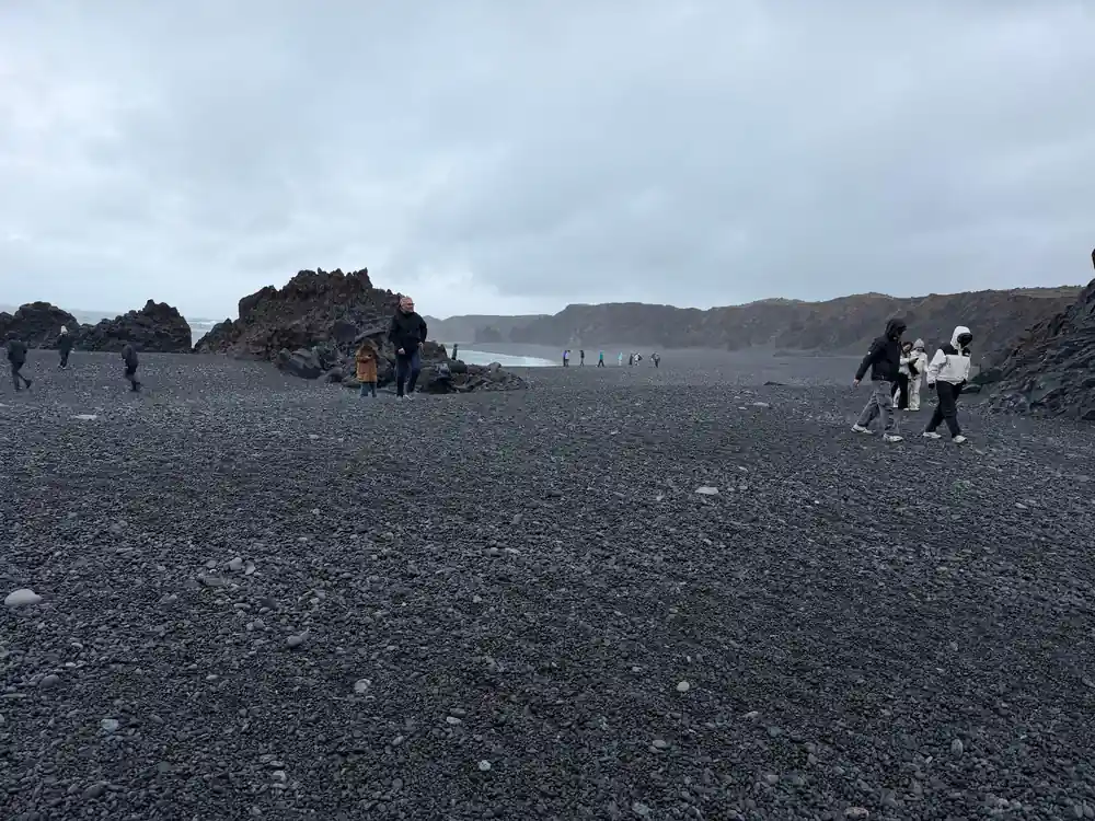 Black sand beach with volcanic rocks and coastal cliffs