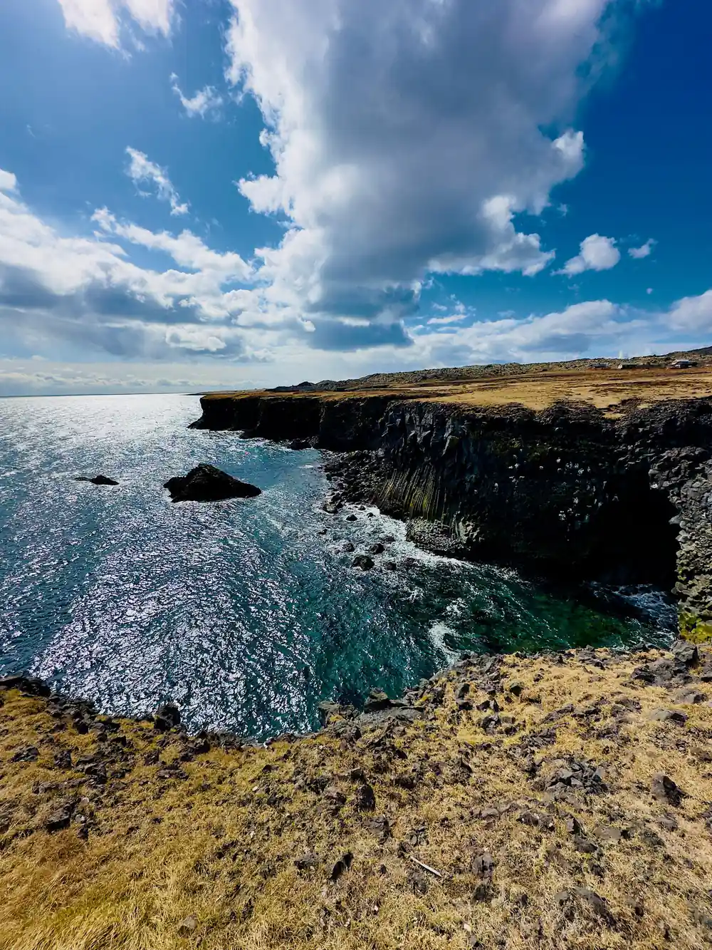 Coastal cliffs and turquoise sea under blue sky