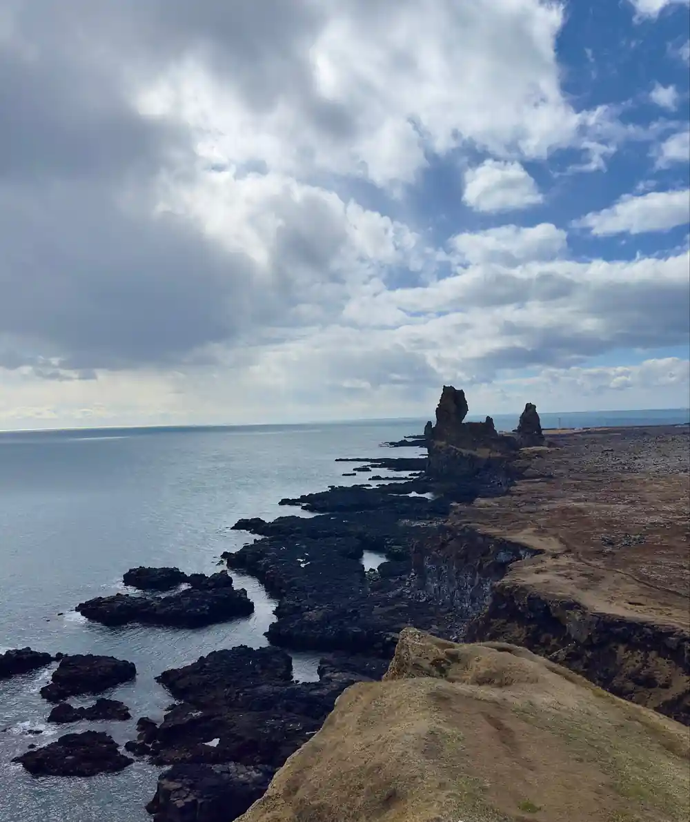 Coastal rock formations in sea with basalt cliffs