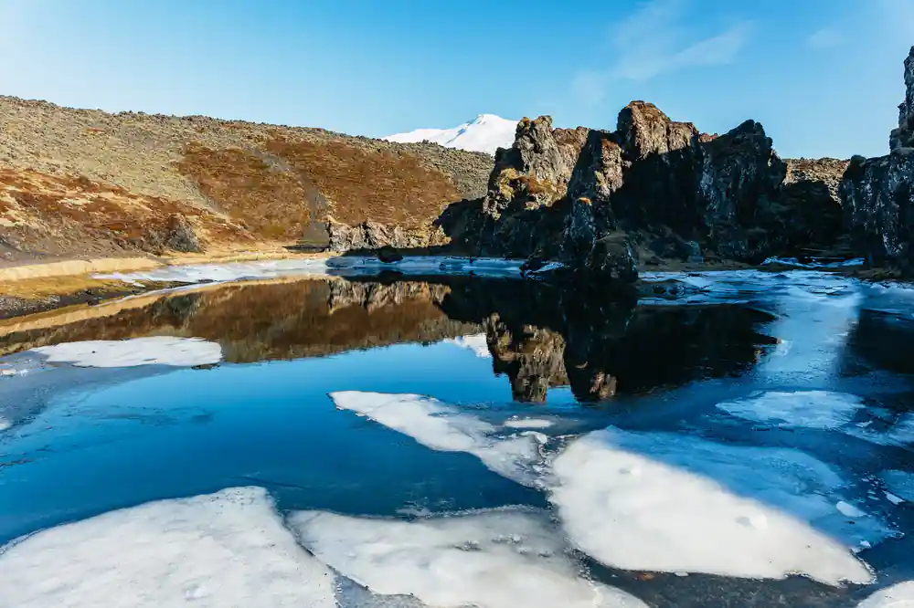 Frozen lake with rock formations reflected in ice
