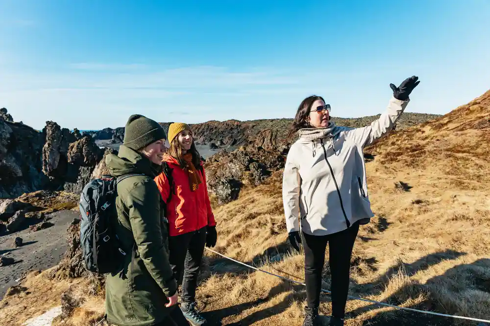 Three people on rocky terrain with basalt formations