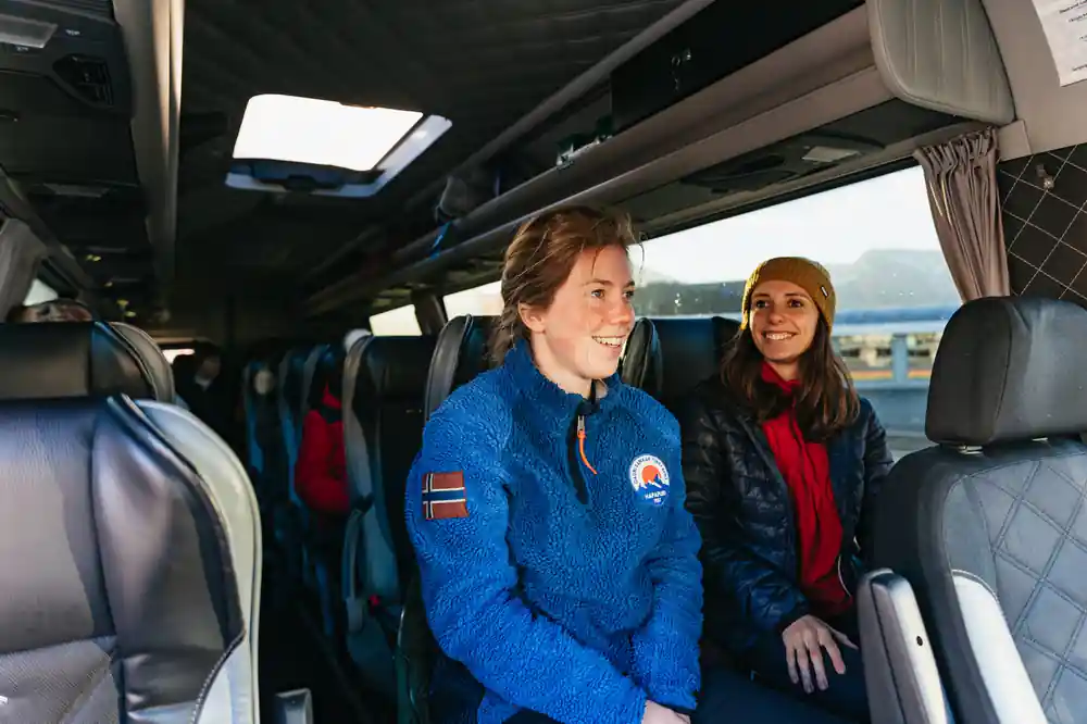 Two women inside minibus with coastal view through window