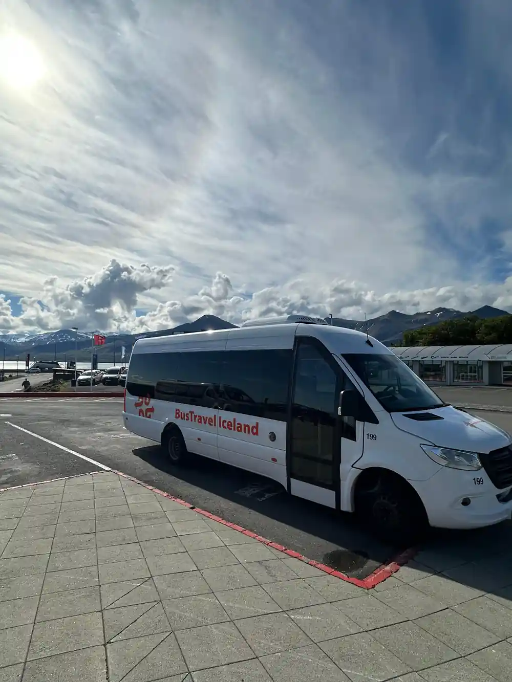 White and black coach bus parked in sunny carpark